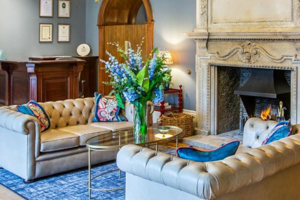 A reception room, luxuriously furnished with two sofas, a coffee table and flowers.