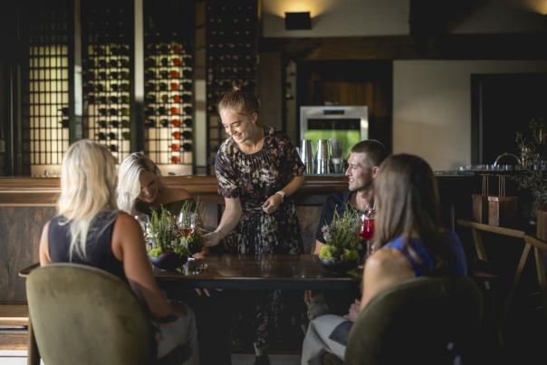 A waitress serving a group of diners at Amisfield Restaurant
