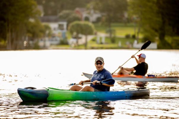 People kayaking on Hope Mills Lake, enjoying outdoor recreation on a sunny day.