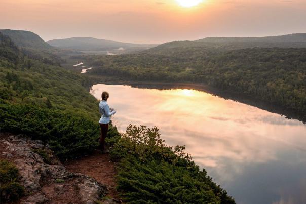 woman overlooking the Lake of the Clouds at sunrise