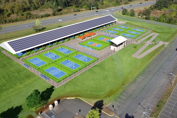 A rendering of an outdoor pickleball facility with over a dozen courts. Covered space with solar panels, stretch along 30th Avenue at Lane Community College.