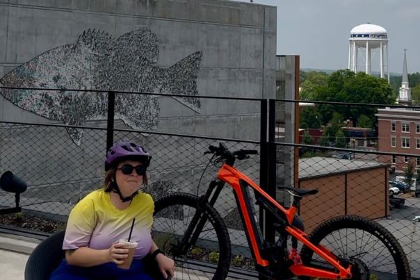 Marley sitting next to her bicycle overlooking the Bentonville water tower