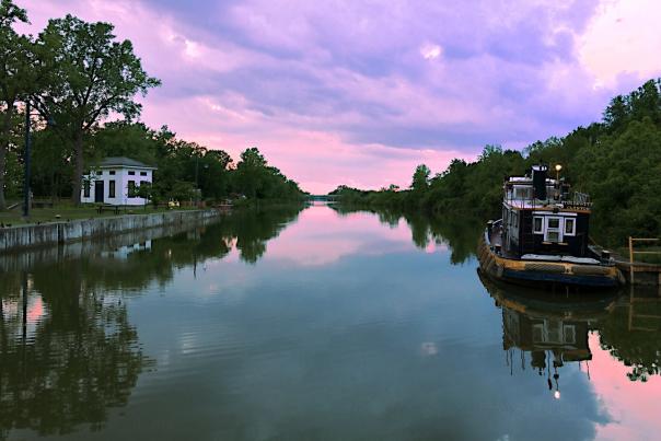 Erie Canal at sunset, with a tugboat on the water