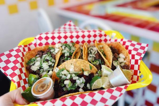 6 carne asada street tacos from TikiTaco served in a colorful basket.