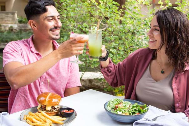 Man and woman toasting each other at the San Antonio River Walk