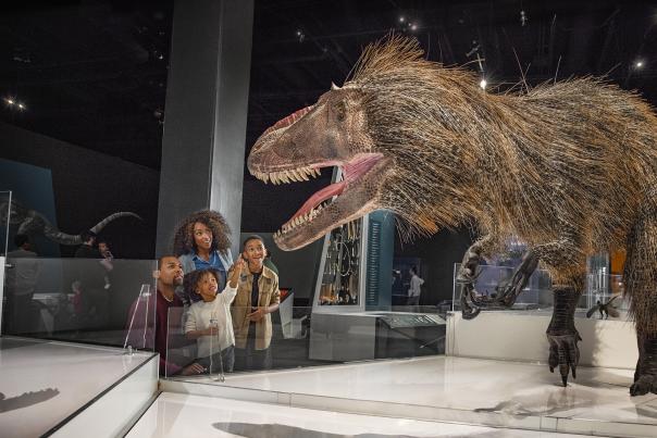 Family admiring life-size dinosaur at COSI