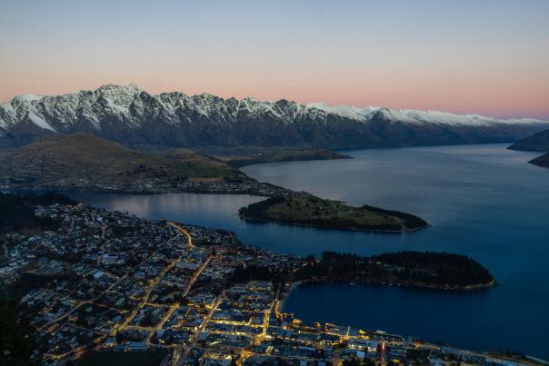 Aerial view of Queenstown at dusk with the Remarkables mountain range covered in snow