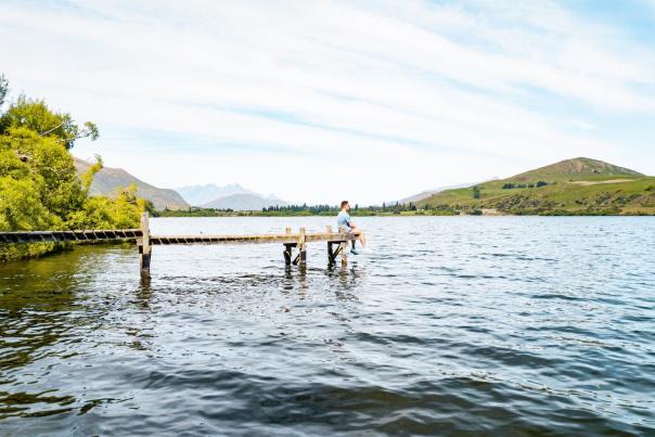 Sitting at the end of a pier at Lake Hayes