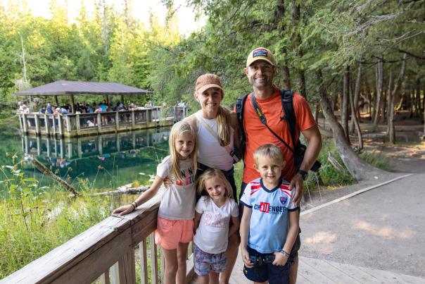 A family standing in front of Kitch-iti-kipi, located in the Upper Peninsula of Michigan