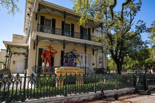 Mobile Carnival Museum, exterior, two story yellow building with black wrought iron fencing