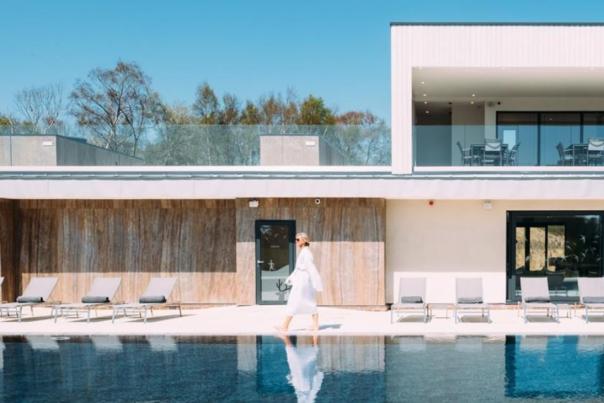 Woman in robe walking next to swimming pool at Silverlake Dorset