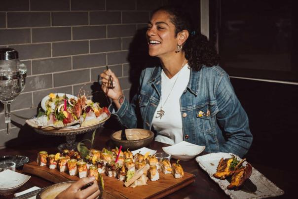 Person eats good food at a table full of different types of food.