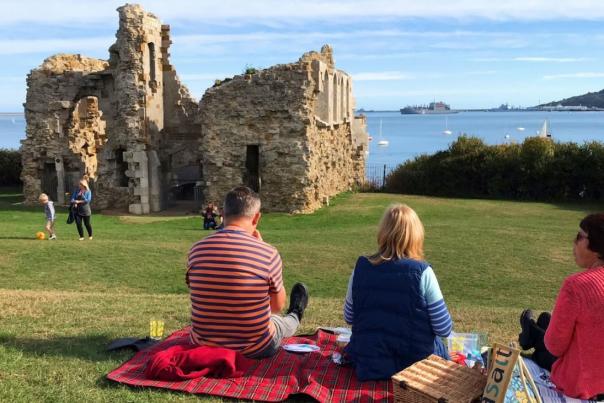Three people having a picnic at Sandsfoot Castle, Weymouth, Dorset