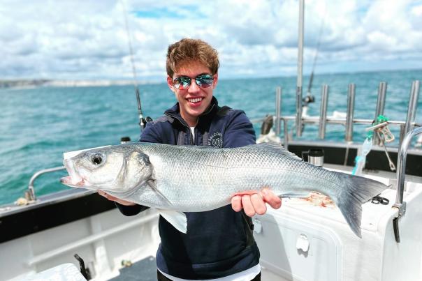 Boy holding a fish on a boat trip with Swanage Sea Fishing in Dorset