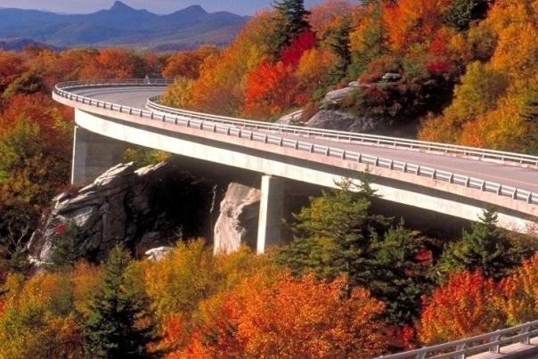 The iconic Linn Cove Viaduct on the Blue Ridge Parkway curves around a mountain surrounded by fall color.
