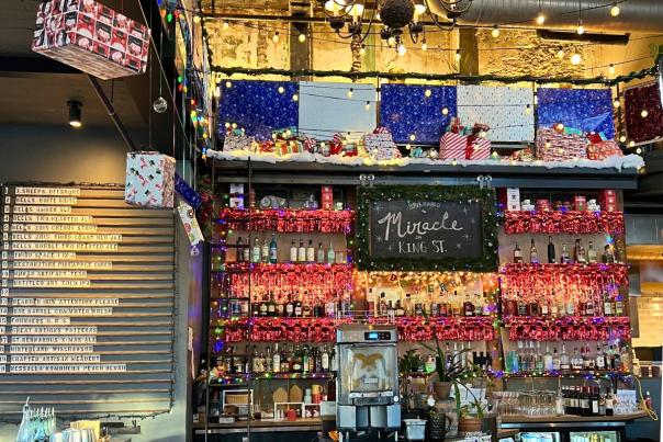 The bar at Lucille decorated in Christmas decor and a sign that says Miracle on King Street