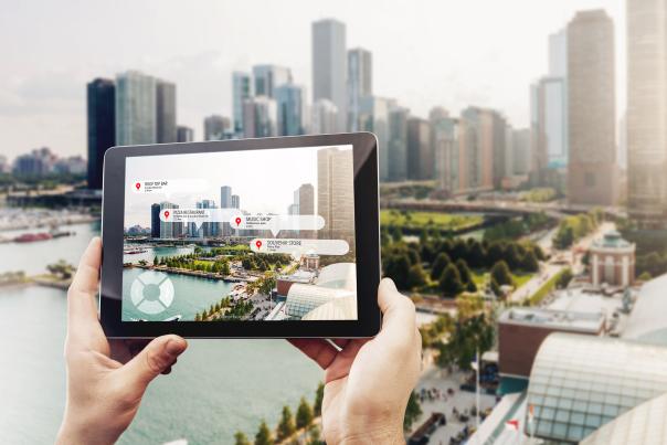 A tablet is held up, showing an augmented reality map of the city.