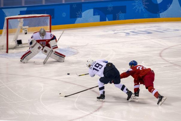 Jim Slater lining up a shot to shoot the puck into the goal.