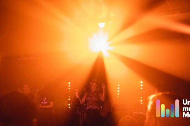 person performing on stage to a crowd of people with Unmissable Music in Manchester logo