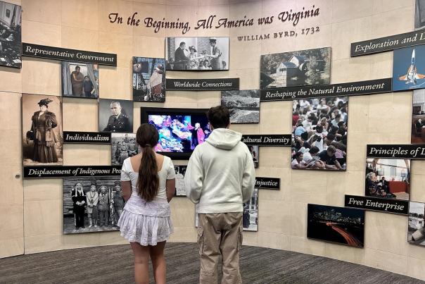 Two teens look at a museum exhibit about the early history of America