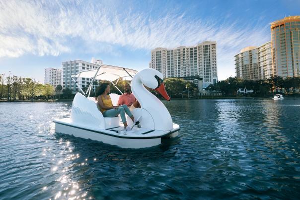 A couple exploring Lake Eola on a swan boat in downtown Orlando