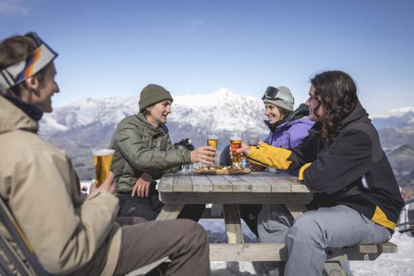 Group of friends enjoying a drink a the top of a mountain