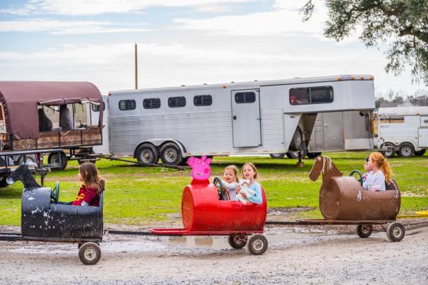 children riding in a toy train at almosta ranch