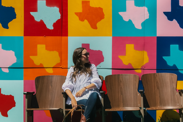 girl sitting in front of Texas mural on route 66 in amarillo