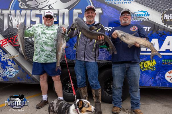 Three men hold up their large catfish caught during the Twisted Cat Tournament in Fort Smith, Arkansas.