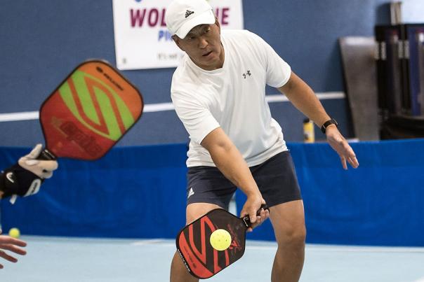 Man and women hitting yellow ball at Wolverine Pickleball