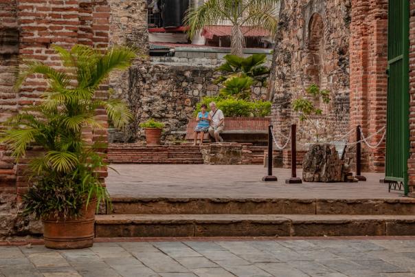 Senior couple of tourists sit at Arco Chato (flat arch) patio. at the Iglesia Santo Domingo in Casco Antiguo in Panama City