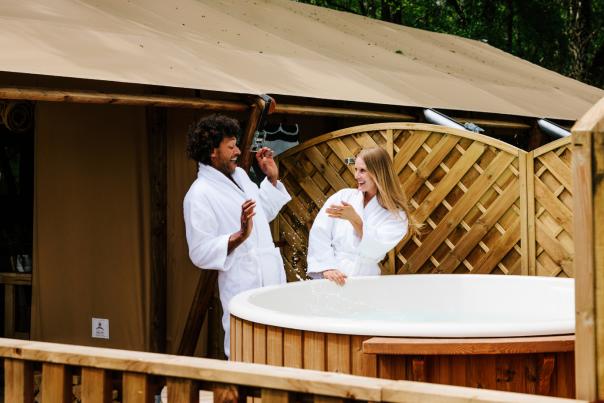 Couple playing by the hot tub at holiday park in the New Forest