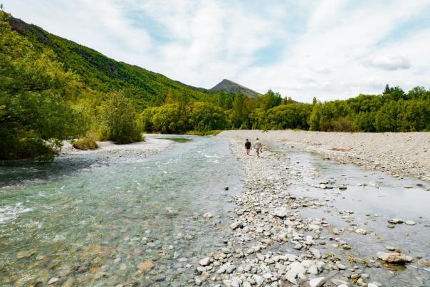 Two people walking the Arrow River, Arrowtown