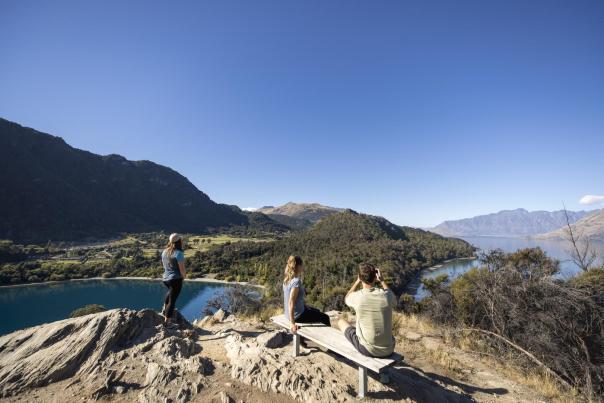 Three people enjoying sweeping mountain and lake views on the Bob's Cove look out point