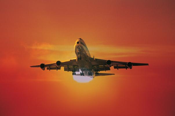 airplane flying at sunset