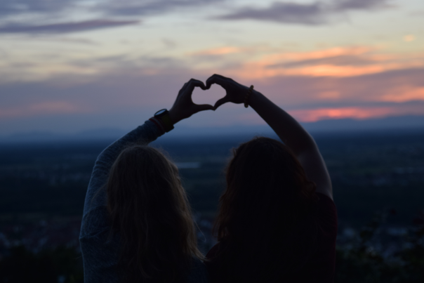 Summer Date Night Blog Cover - Couple Forming Heart with Hands, Looking out at Sunset