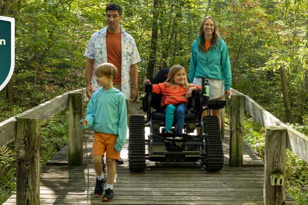 Family on hiking trail, girl in motorized wheelchair