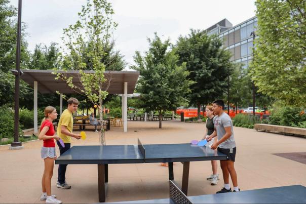 A group of teenagers playing ping pong at The RiverFront.