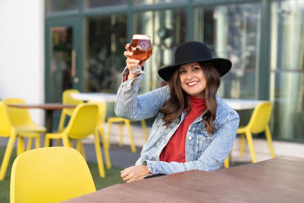 Woman holding up a glass of beer at Greenwood Brewing