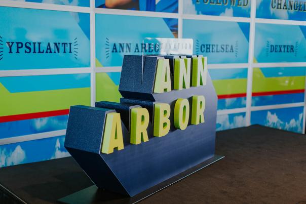 Large sculpture of Destination Ann Arbor logo in green and blue