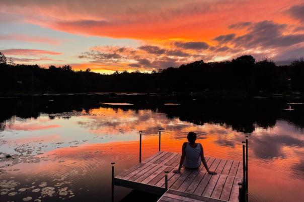 A visitor enjoys a beautiful sunset over a lake in the Pocono Mountains