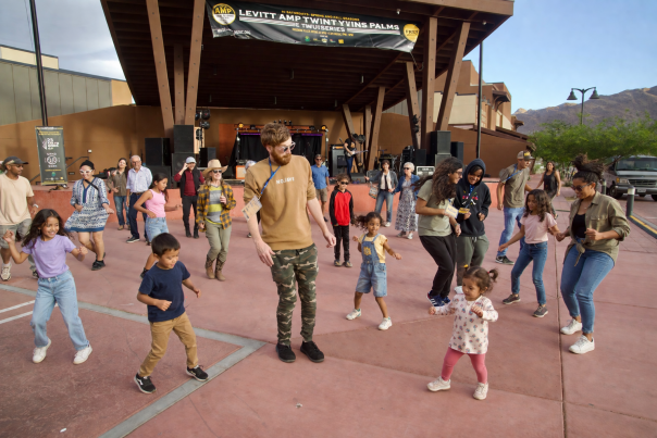 Families and community members dance together during a Levitt AMP Twentynine Palms Music Series concert at Freedom Plaza in downtown Twentynine Palms, California.