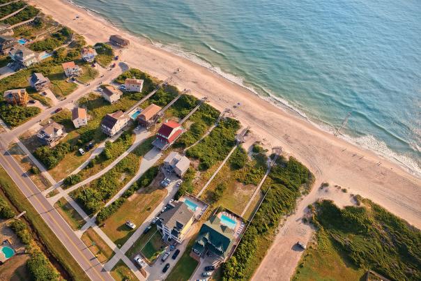 An aerial shot of beach-front rental homes situated on the coast of the Outer Banks in North Carolina.