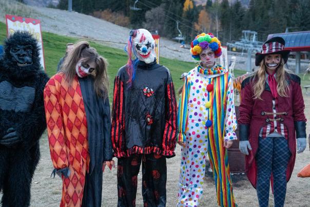 a group of spooky lift ride workers including a gorilla, harley quinn, 2 scary clowns and a spooky ringmaster