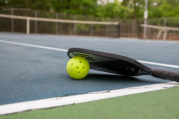 a pickleball ball and paddle on a pickleball court at Shallotte Township District Park