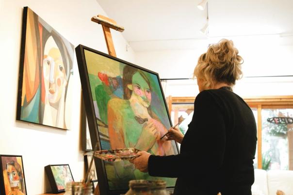 An artist painting on an easel.
