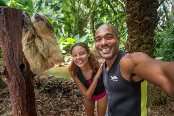 A couple with a sloth at Discovery Cove Animal Trek