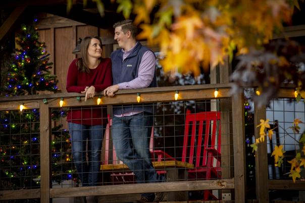 Couple standing on deck with Christmas tree