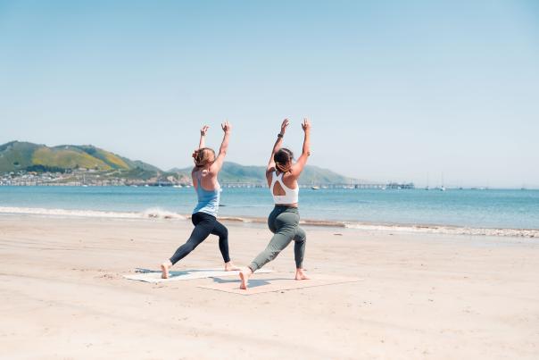 girls doing yoga on the beach