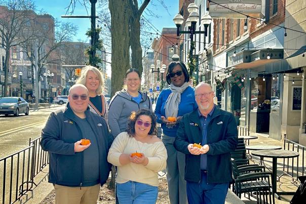 Destination Ann Arbor Sales Team downtown holding mini pumpkins